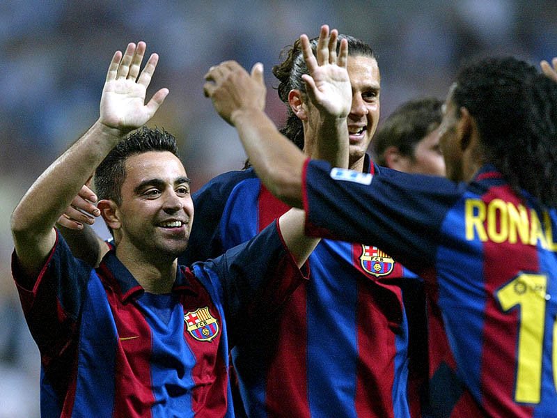 L’été 2003 marque un premier tournant dans l’histoire de Xavi au Barça grâce à deux arrivées et non des moindres : Frank Rijkaard sur le banc et Ronaldinho en tant que meneur de jeu..Ces venues doivent redynamiser le Barça et ça va être le cas, Xavi lui, devient métronome..