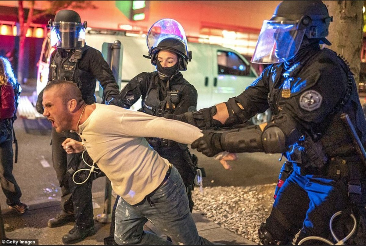 JackPosobiec's tweet image. Police officers holding back a man who was with the victim of the deadly antifascist shooting last night in Portland