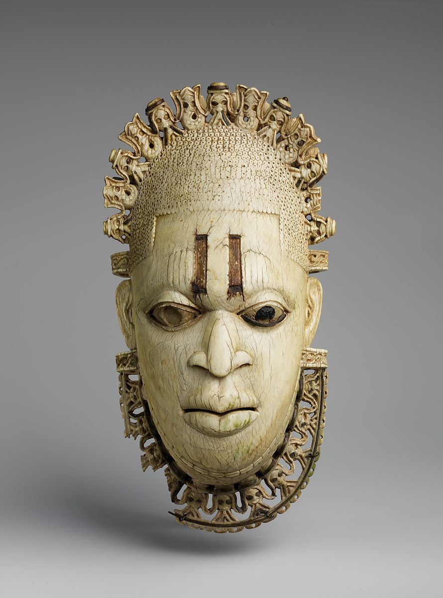 Or even Olokun, the ocean-being that was connected to the wealth, abundance, and trade by water of the Benin Empire. The Iyoba Pendant Mask actually pulls in attributes that praise Olokun, like the ivory itself and the mudfish on her crown.