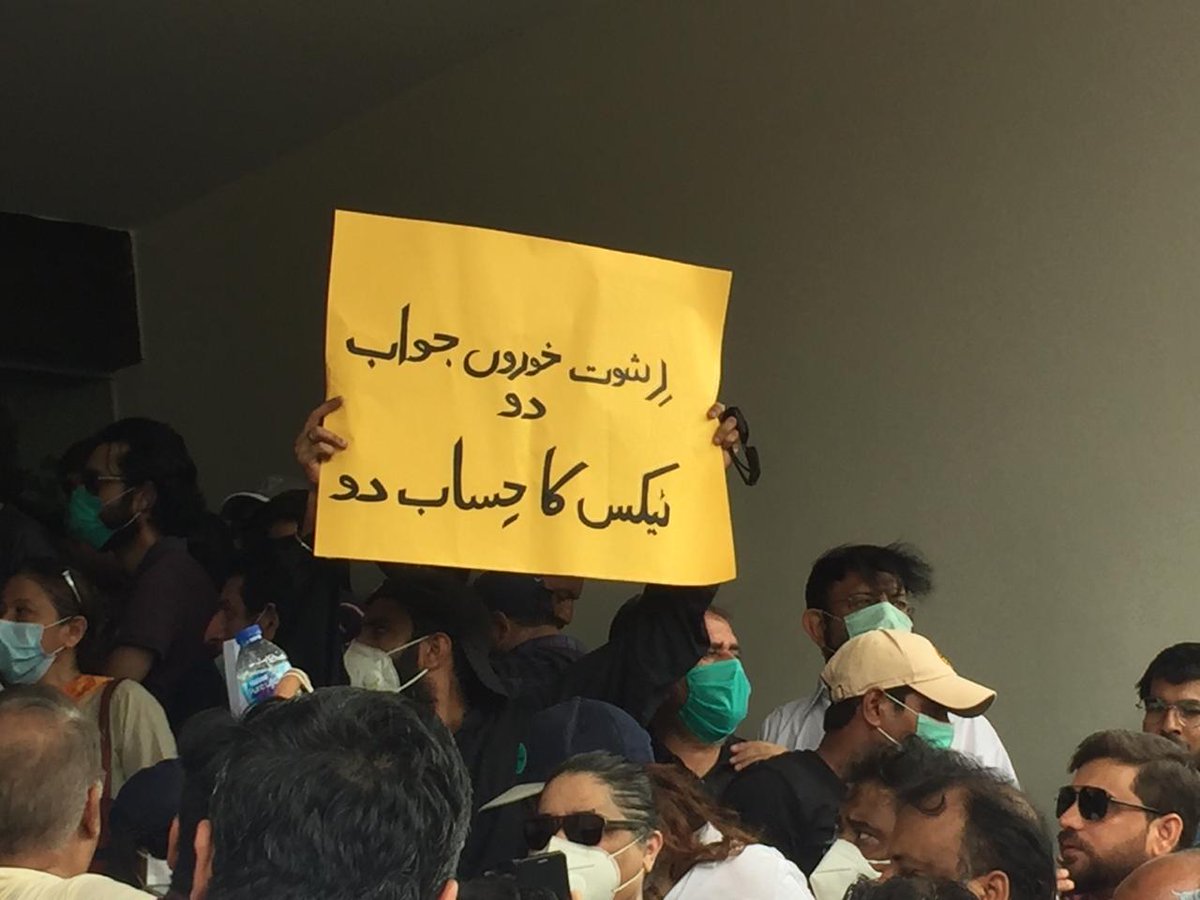 LIVE: "Bribe-takers answer us," says this poster from the DHA, Clifton Cantonment Board protest. Office surrounded in Karachi.