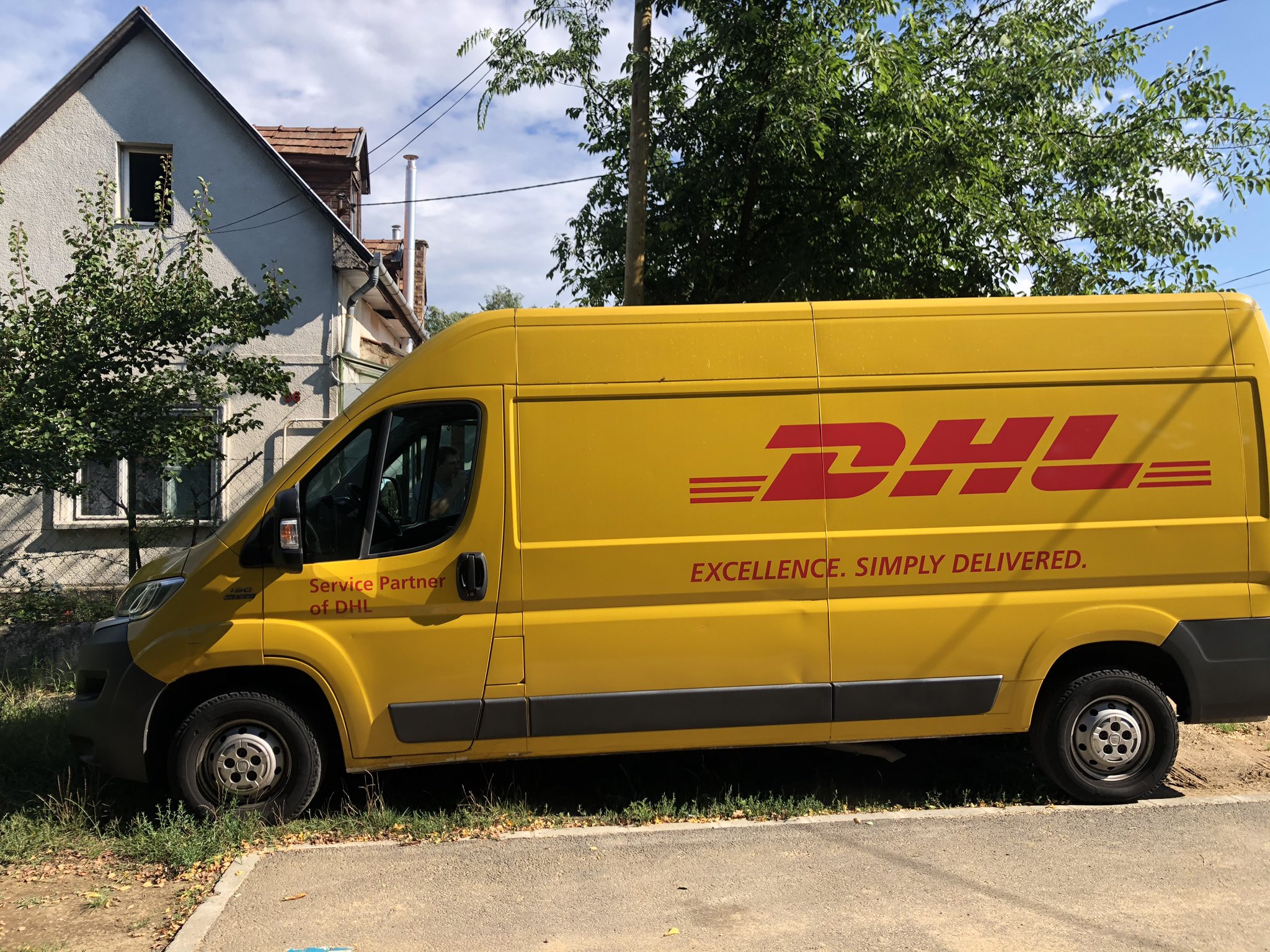 Courier Enters DHL Yellow Delivery Van After Delivering The