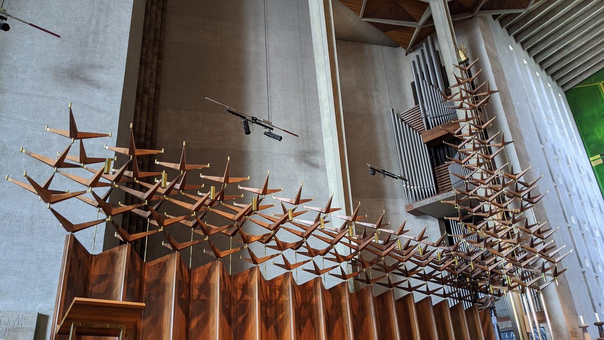 Immediately inside you're struck by the great tapestry of Jesus that covers the East wall, and in front of it these gorgeous choir stalls with geometric wooden decorations that almost look like origami birds taking flight.