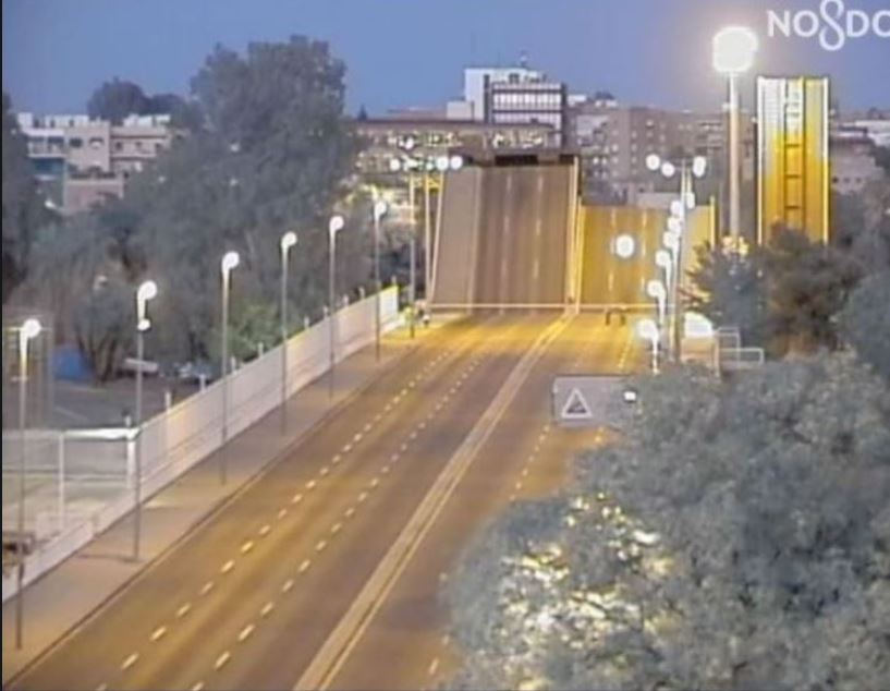 Imagen de archivo del Puente de las Delicias tomada desde cámara de tráfico donde se observa el puente cortado al tráfico y levantado en un atardecer.