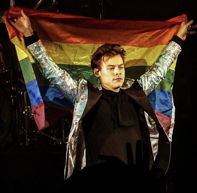 Harry Styles holding pride flags.