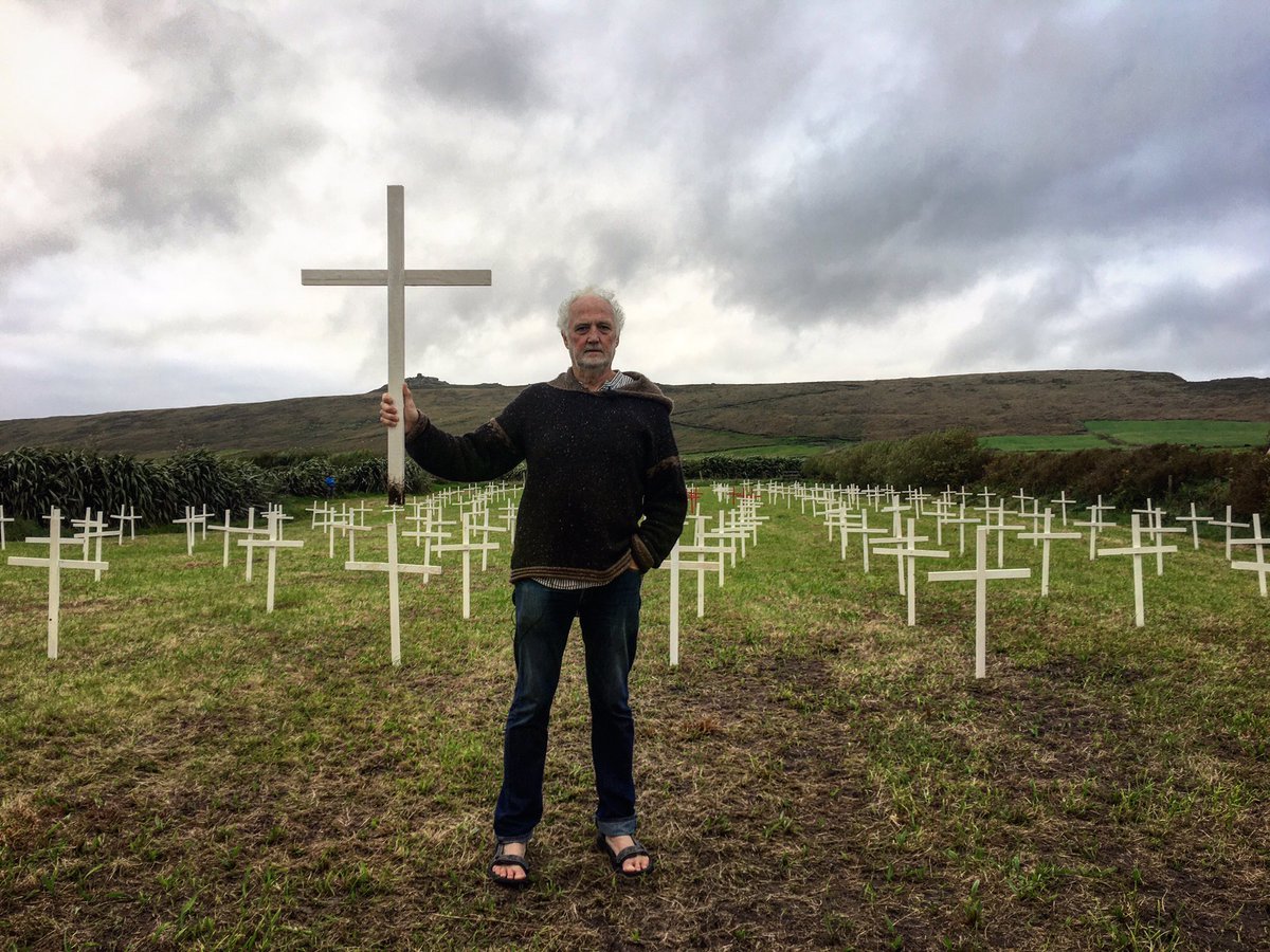 Buailtin's tweet photo. Musician Breanndán Begley has erected 235 crosses in his field as protest against rural planning policies. He has been ordered to remove a trailer-cabin he built without permission or face fine of €12m or jail. 235 crosses represents pop. of Baile na bPoc in 1841. Today pop. 12. https://t.co/L7omdQv4mX