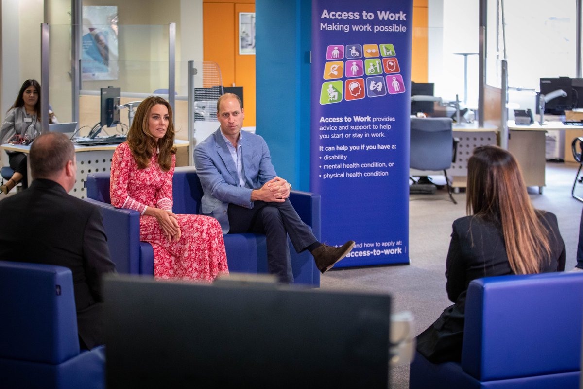 HRH The Duke and Duchess of Cambridge sit and listen to staff chatting with them inside the jobcentre.