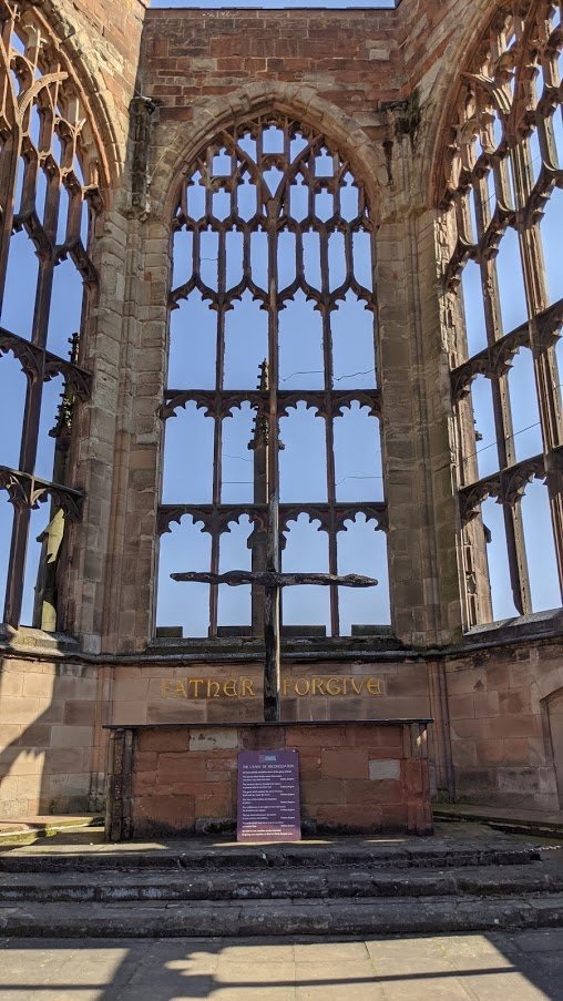 On the wall, behind the altar of the old, bombed-out cathedral, are the words "Father Forgive" in large carved and gilded letters.