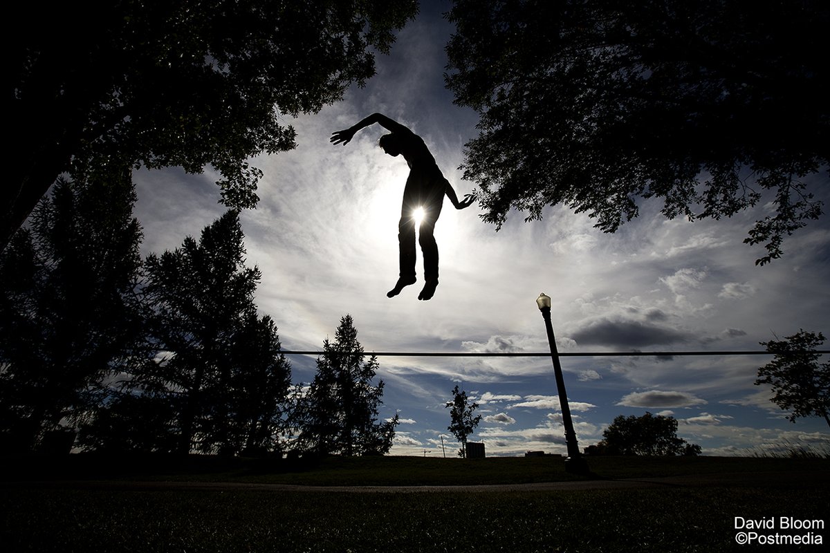 Daniel Anderson leaps in the air as he slacklines in Constable Ezio Faraone Park. Anderson was jumping into the air from the slackline and landing back on the line. #MidShiftPhotoWanderings #yeg
