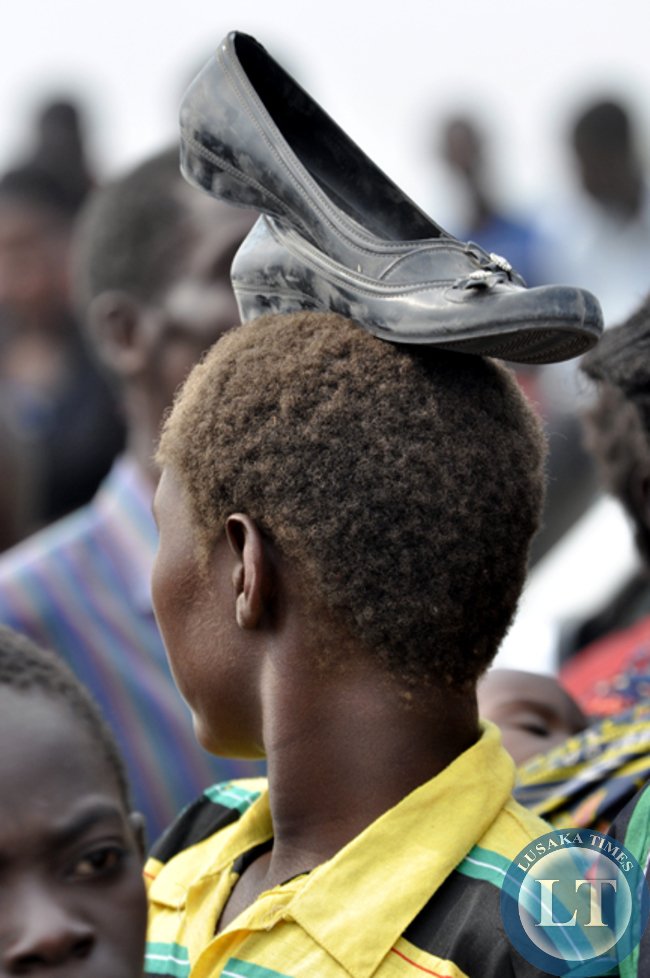 t24/ A young girl keeps her shoes safe during the Mukulapembe ceremony.