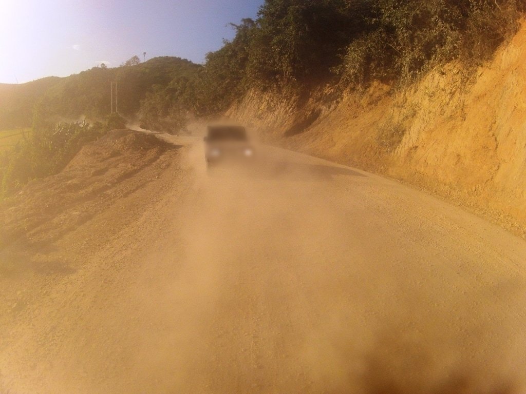 пыль от автомобиля. пыль на дороге. пыльная грунтовая дорога. пыльные дороги в городе. пыльная дорога.