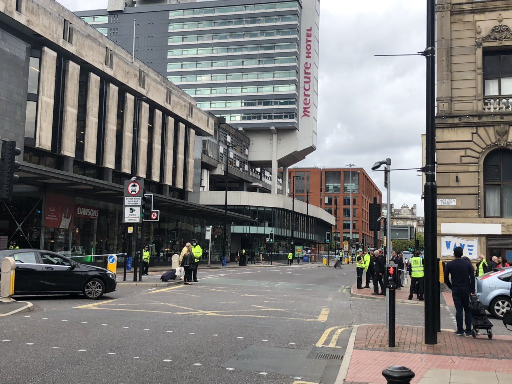 SassyThrandy's tweet photo. Big police presence and entire Piccadilly Gardens and bus station taped off. Police are advising everyone to stay as far back as possible. Confirmation of a suspicious item on one of the buses in the station. Avoid area if possible. #Manchester #ManchetserCity #Police https://t.co/TwuJO5sKXs