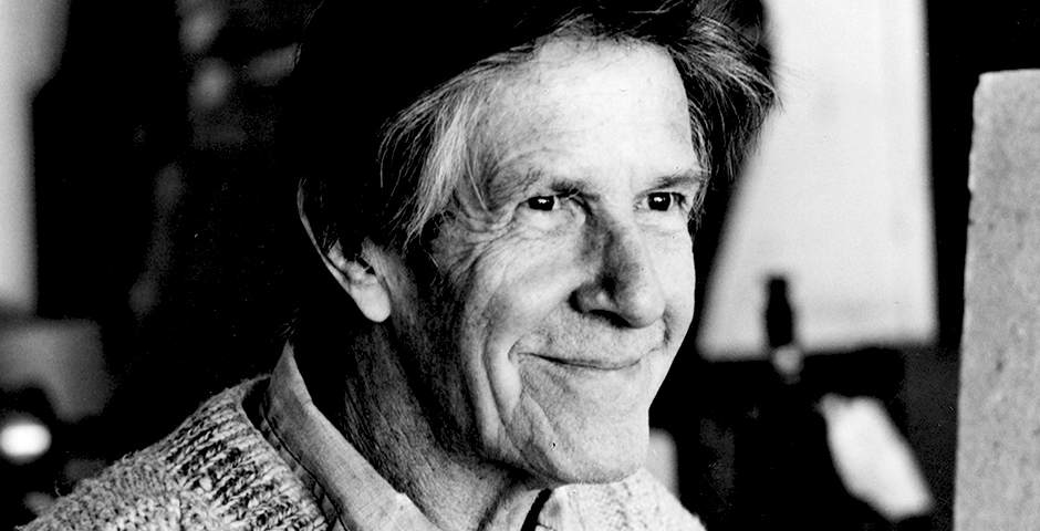 black and white photo of a smiling John Cage