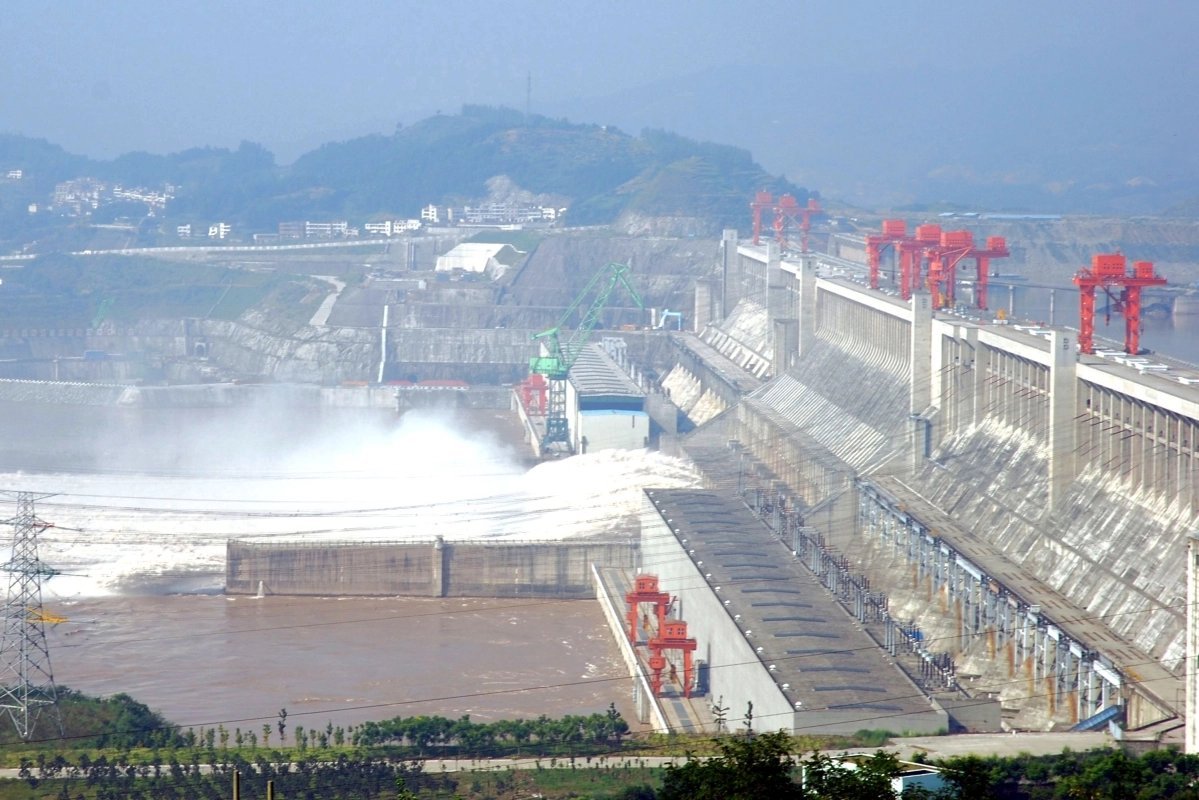 Note the huge red mobile cranes on the top which are about three stories high. The lower ones are a little smaller, but pay attention to the horizontal wall behind them and in front of the spillway water discharge. We'll come back to that.