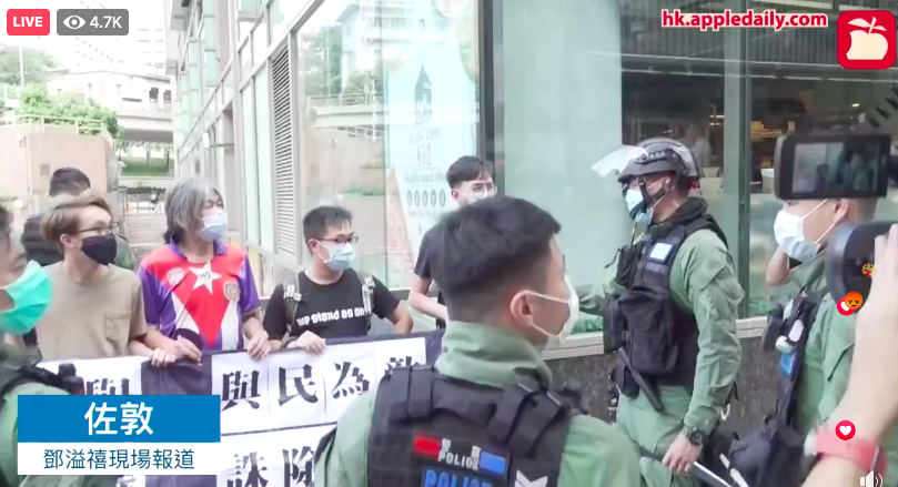 Riot police surrounded activists of League of Social Democrats and warned they had violated ban on social gathering as soon as the activists showed a banner and chanted slogans opposing delay of LegCo election.