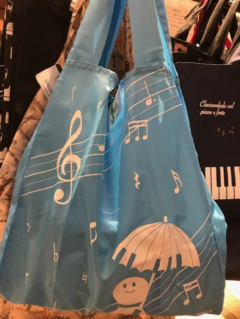 ヤマハ銀座店 エコバッグ入荷 楽器が散りばめられたオシャレな柄のバッグと 鍵盤柄の傘をさした可愛い てるてる坊主 の バッグが入荷 どちらもポリエステルで軽く 小さくたためて便利です ミュージックエコバッグ 800円 税 Happy Days折りたたみ