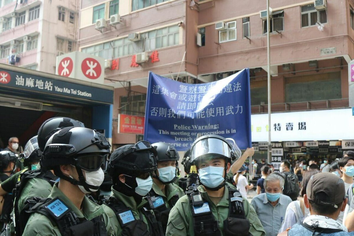 VerbatimHKG's tweet photo. 1530: riot police stopped and searched everyone including pedestrians at the exit of Man Ming Lane at Yau Mei Tei MTR. 

Police hoisted a blue flag as a warning. Photos captures the young and old, encircled by the police on a Sunday originally set to vote for Legislative Council. https://t.co/VBUHhgPGu6