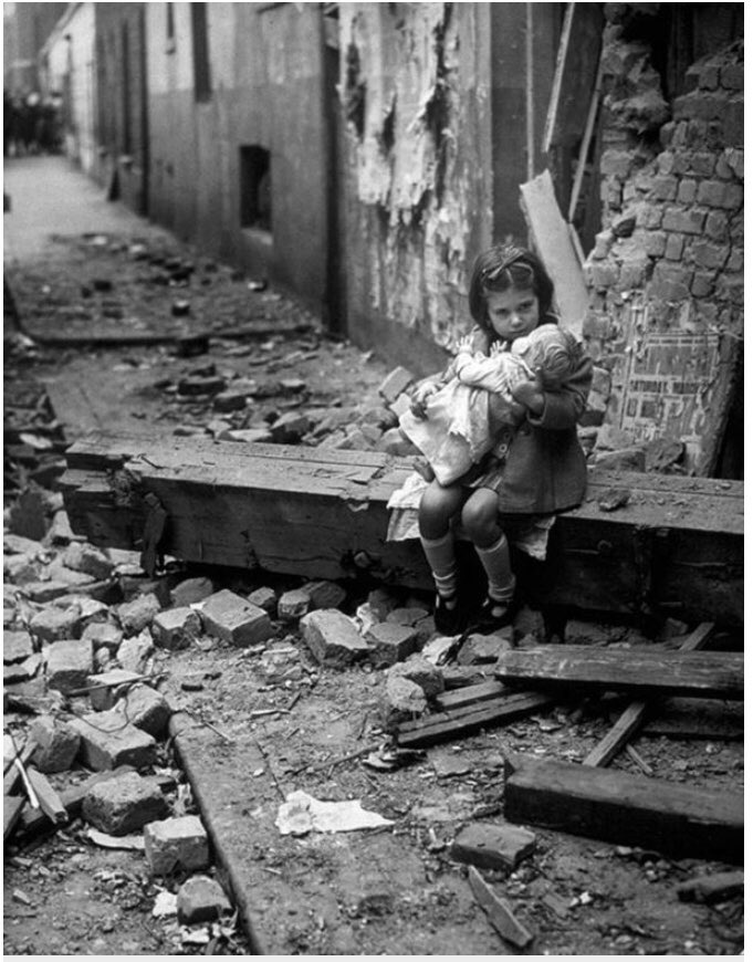 Une petite fille tenant sa poupée dans les ruines de sa maison à Londres, 1940 