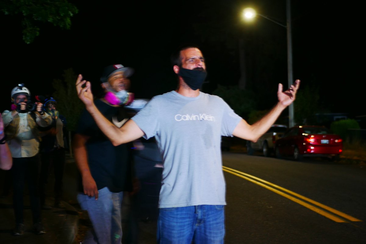 9/5 2305-2307 Officer points rifle with mounted light at protester in gray. He's joined in front of the line by another protester, before briefly kneeling in front of the police. #pdxprotest  #BLM  #portland  #blacklivesmatter    #portlandprotest  #defendpdx  #BLMprotests