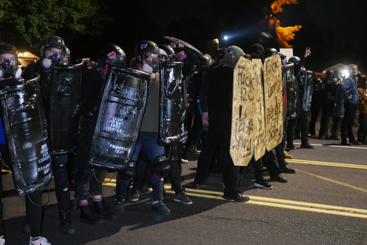 9/5 2114-2119 Shield reading "100 DAYS 100 NIGHTS" waits for PPB advance before a molotov is thrown. Event is quickly declared a riot and shield wall retreats.  #pdxprotest  #BLM  #portland  #blacklivesmatter    #portlandprotest  #defendpdx  #blmprotestvideo here:  https://twitter.com/BaghdadBrian/status/1302464110676729857