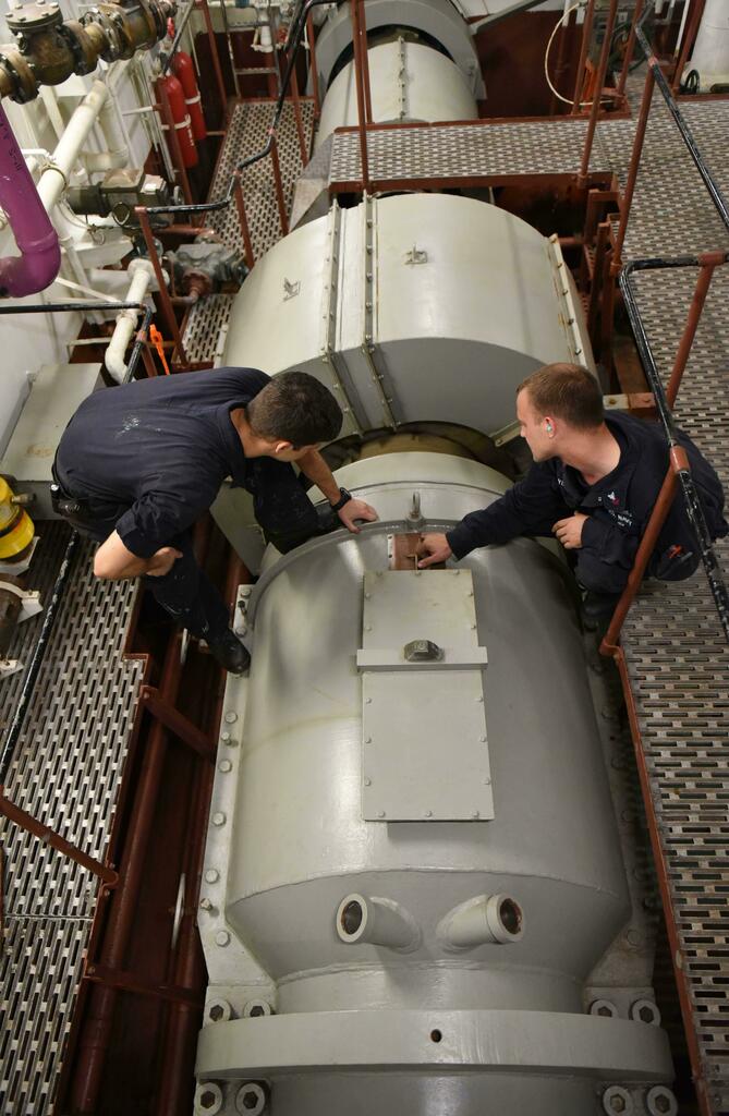WarshipPorn's tweet photo. [3840 x 5880] ATLANTIC OCEAN (Oct. 19, 2017) Machinist's Mate 1st Class Robert Denoya teaches Machinist's Mate Fireman Apprentice Tyler Prince about line shaft bearings and flow characteristics in shaft alley aboard the aircraft carrier USS George H.W. B… https://t.co/iXglFt2l4Q https://t.co/VsjEQVMTwq