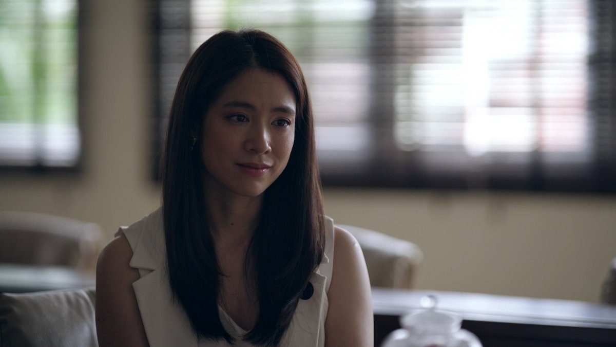 The way Ms. Darin and Namtan's character resembles each other very much will make you think Namtan was the younger version. However, Ms. Darin appears to be relatively young compared to the present Director. Also, the way she speaks with director doesn't look like +