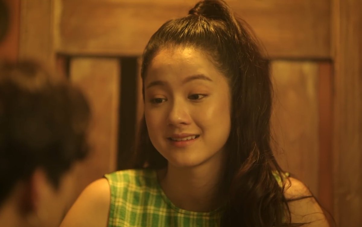 The way Ms. Darin and Namtan's character resembles each other very much will make you think Namtan was the younger version. However, Ms. Darin appears to be relatively young compared to the present Director. Also, the way she speaks with director doesn't look like +