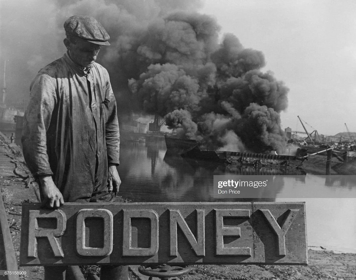 Robert Ellis, a former Chief Petty Officer aboard the Royal Navy Nelson-class battleship HMS Rodney, now holds onto her nameplate as a crane operator assisting in the process of the battleship being scrapped at the Thomas W Ward shipyard on 4 September 1950 2/3