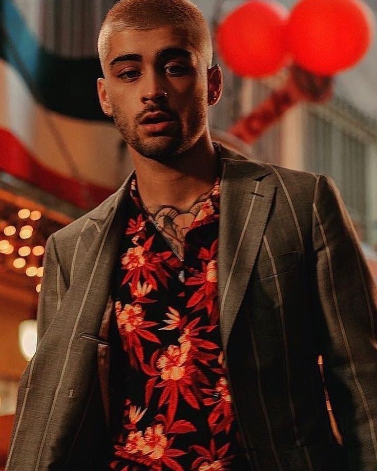 Zayn wore a gray Salvatore Ferragamo suit worn over a tropical print shirt from Justin O'Shea's new SSS World Corp line.