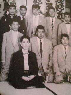 ボンノネギ夫 最前列の黒いスーツが金子信雄が演じた共政会初代山村辰雄氏 その後方右手が菅原文太が演じた美能幸三 氏 左手が成田三樹夫が演じた網野光三郎氏 後列中央は田中邦衛が演じた樋上実氏 後年美能組組員に射殺されます そして後列左は松方弘樹