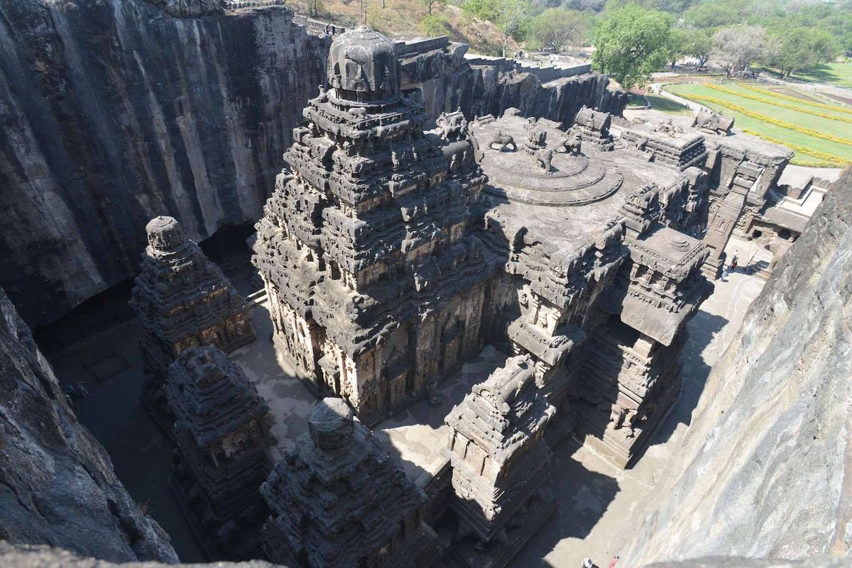 Graham__Hancock's tweet photo. India: Kailashnath Temple, Ellora Caves complex. From a glance at the photo by my wife Santha Faiia it's hard to realise the scale, but find the people in the shot and you'll begin to get the idea. The temple isn't "built". It's carved, inside and out, from solid basalt bedrock. https://t.co/r0FwrAmuGR