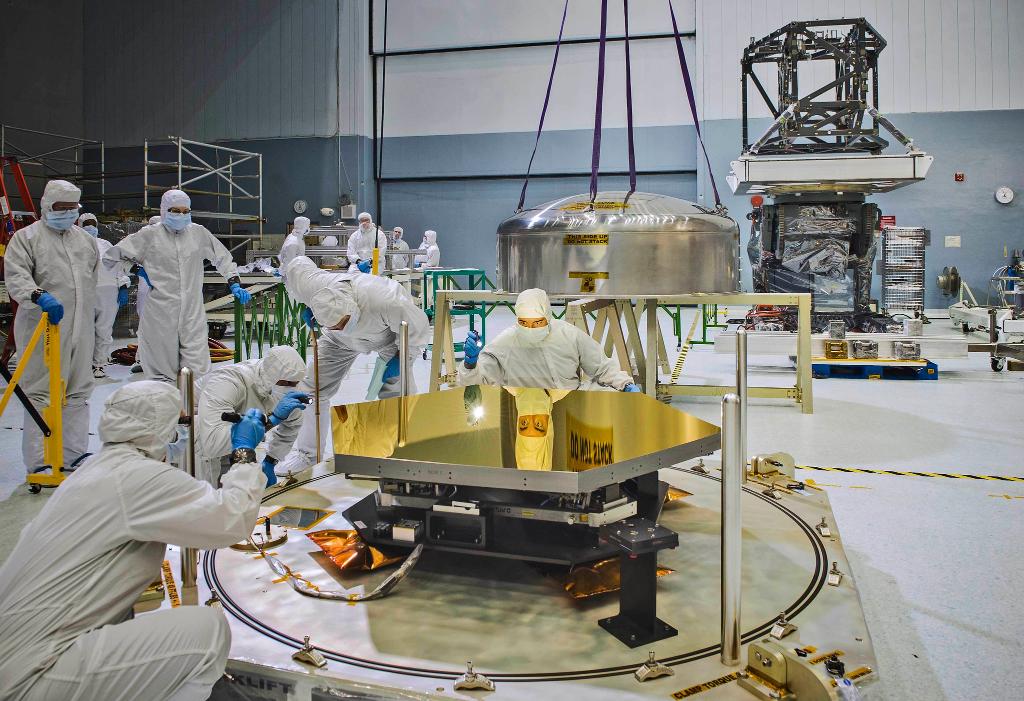 Webb technologists examine one of the telescope's golden mirrors