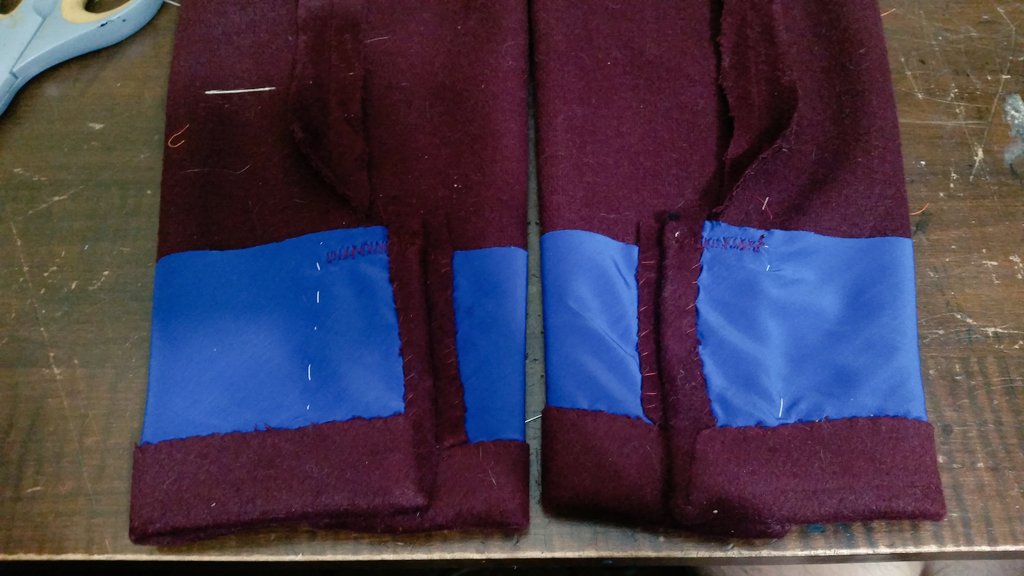 Getting the sleeves ready. A piece of pocketing is used to reinforce the area. The book said not to trim away the excess fabric in these mitered edges, but my fabric is so thick I did so. You also don't clip the seam allowance at the vent, just press it diagonally
