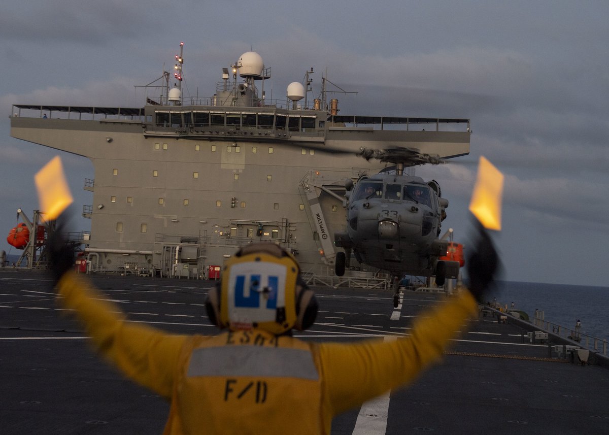 USNavyEurope's tweet photo. Airman Francisco Clark lands an #MH-60 Seahawk helicopter assigned to Helicopter Sea Combat Squadron 28 on the flight deck of the Expeditionary Sea Base #USSHershelWoodyWilliams in the Mediterranean Sea. https://t.co/Ks3H0RXe5H