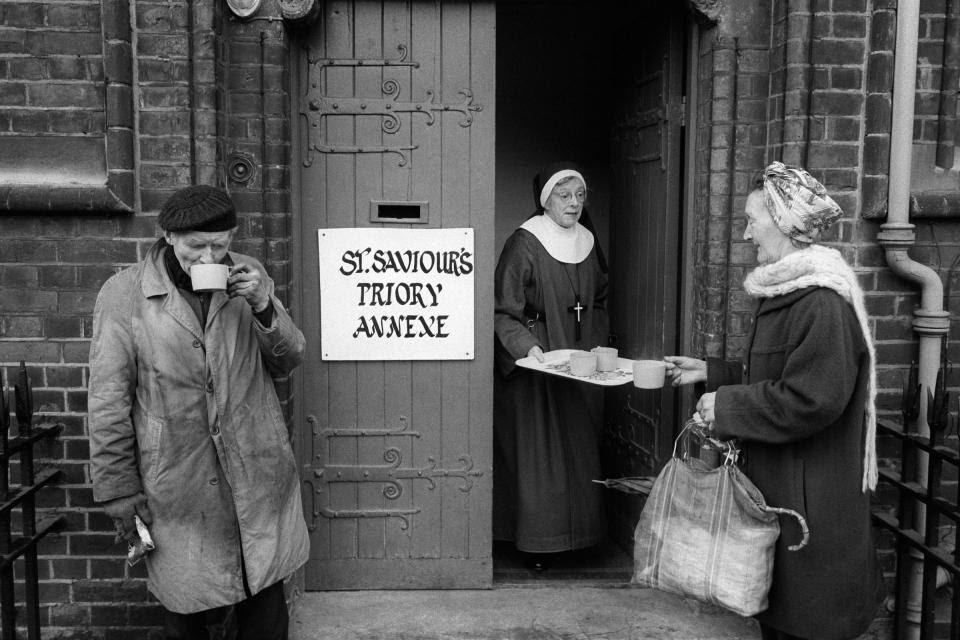 Hoxton, London, 1978.Sister Patricia hands out cups of tea from St Saviour's Priory annex on the Kingsland Road. The Sisters explore ways of living the religious life in the community through a balance of prayer and ministry amongst marginalised groups -  @HomerSykes