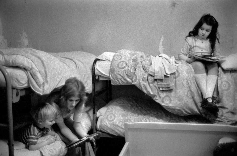 Richmond, London, 1975.  Mum reads a bedtime story; it was their first Christmas away from the family home. Sadly many mothers and children often remained in this refuge for up to three or four years before being rehoused by the authorities. -  @HomerSykes