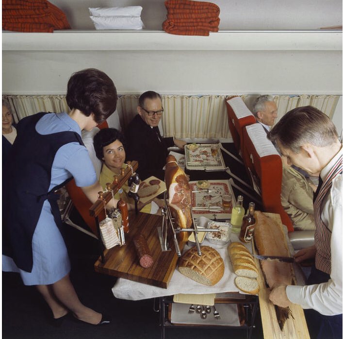 Une hôtesse de l’air servant un buffet traditionnel danois  sur un vol Scandinavian Airlines (1969)