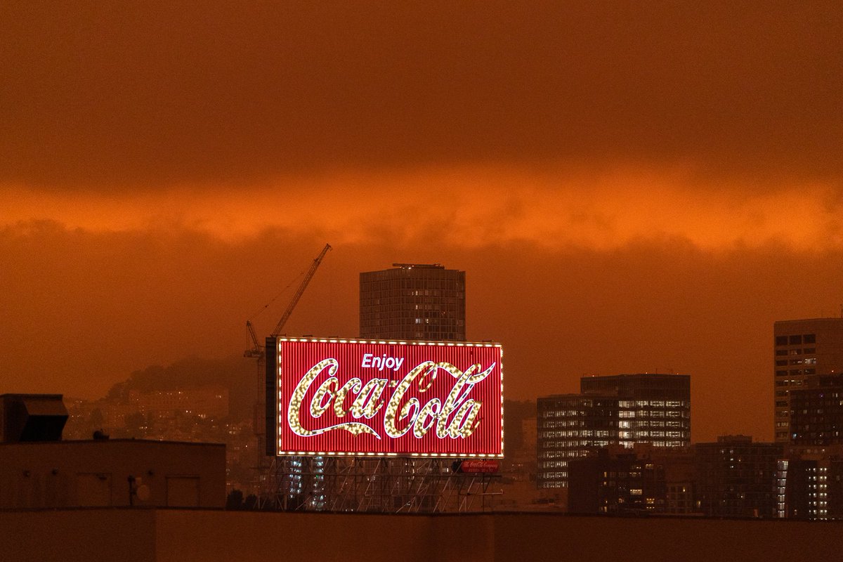 jkimphoto's tweet photo. People across the Bay Area have woken to a surreal scene: smoke from wildland fires across the state have blown in, painting the sky shades of orange. Salesforce Tower is barely visible and the Coca-Cola sign still shines bright as the sun tries to pierce through.

#SanFrancisco https://t.co/mHzdkszxLX