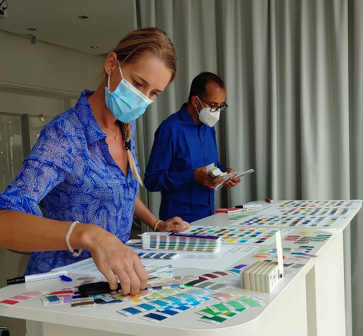 _colorworks_'s tweet photo. Two of our designers collaborate (safely) and savor the moment the entire team has been waiting for all week, namely picking the right reds... and more... for our brand new #colorforward2022 #trendstories #trendforecasting https://t.co/dM5Qf99cMi