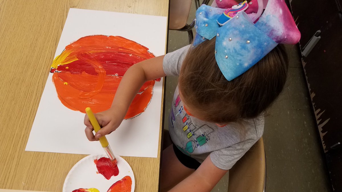 Kindergarteners on day 2 of Art. Incorporating Line, Shape  and Color  as they draw and paint pumpkins!