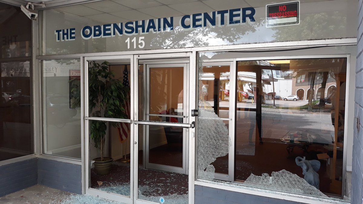 The first set of windows is broken while the second set seems untouched. There were 4 people sitting in the lobby. The glass lay sitting on the ground when I took this picture at 2 PM. After taking the photo, a woman came out to go next door. She went under the door instead push.