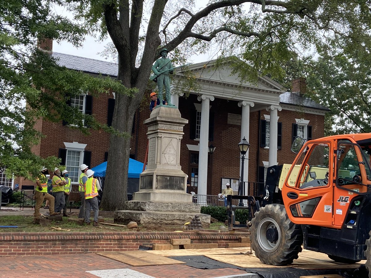 a workman is inspecting the place where the statue is attached to the plinth. i think there are a lot of unknowns about the specifics of the structure.