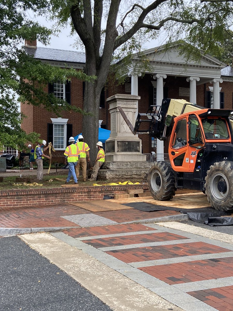 workmen considering the empty plinth. it’s raining now.