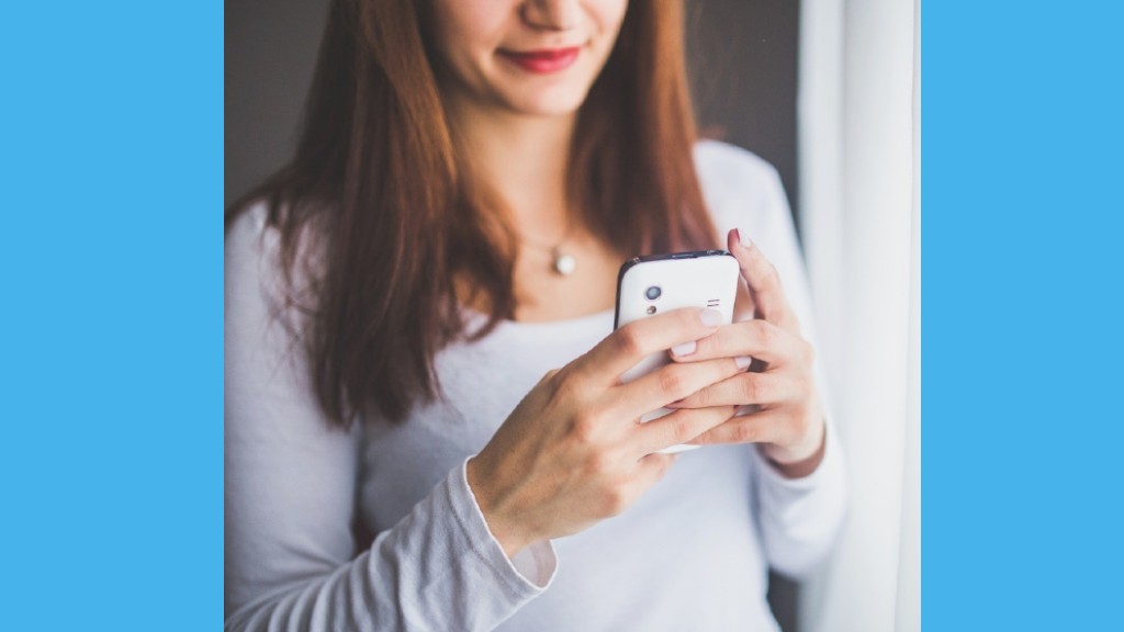 a woman looking down at her smartphone smiling