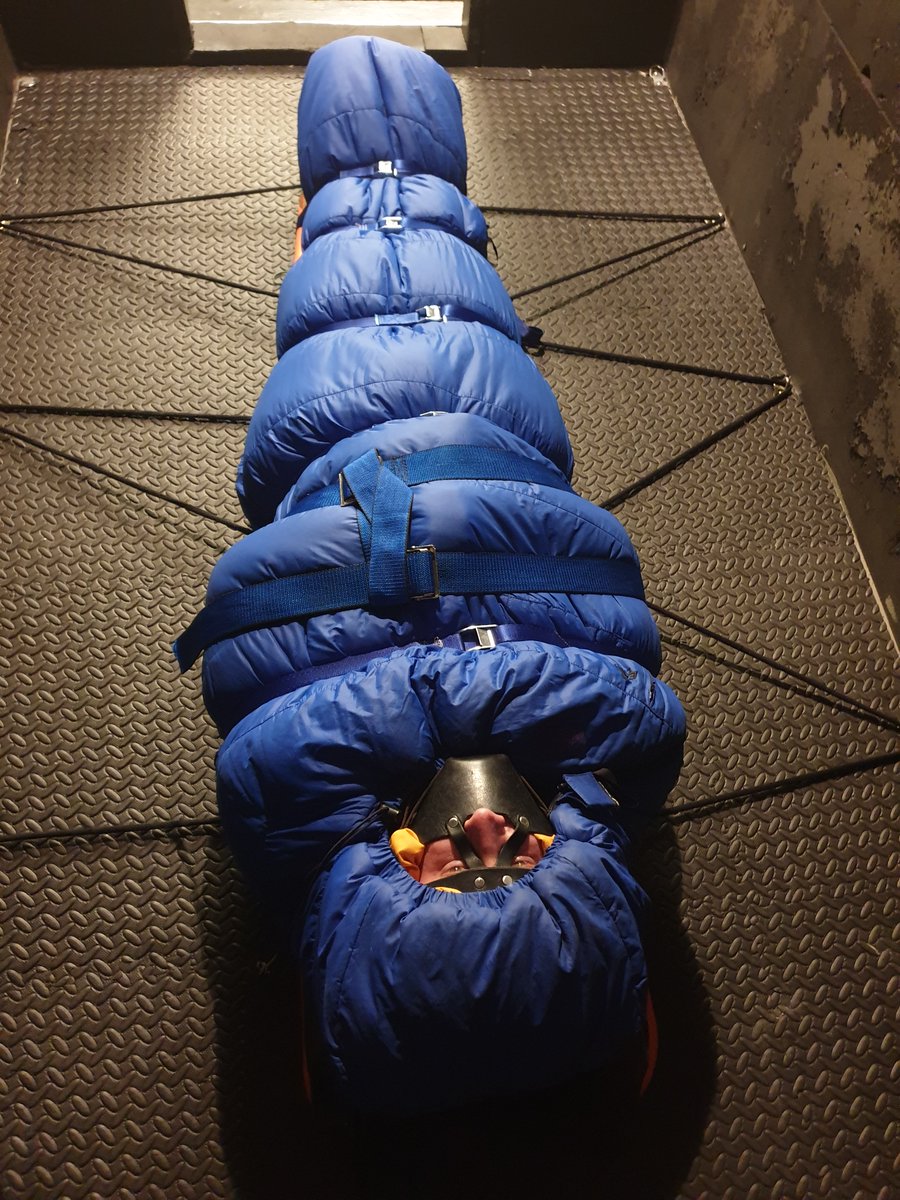 yohan555's tweet photo. After about 2.5 hours in the padded box, transferred Cat the Wolf to the black cell, put him in a sleeping bag in his down gear, straitjacket still on, and then strapped him down to the spine board with cam straps. The board then further anchored to the cell with some rope. https://t.co/rsTYdFu1oj