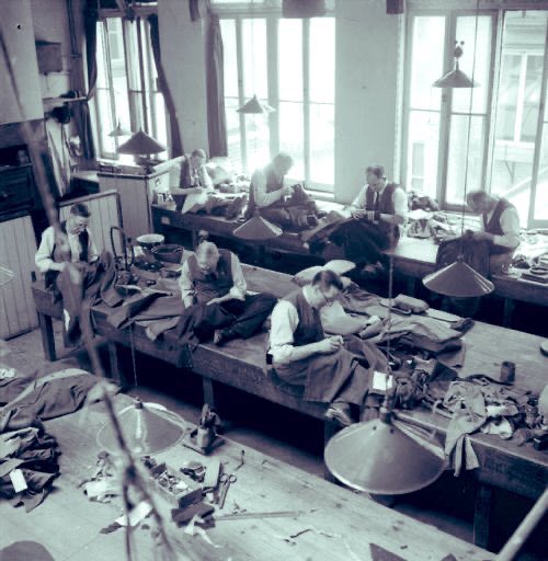 Even the way they sat was mocked- but sitting cross legged on a board was practical- relatively comfortable, allowed movement, & kept material off the floor.Look how long it lasted- LOVE these images of a tailors’ workshop, 19C, and Saville Row 1940s, below