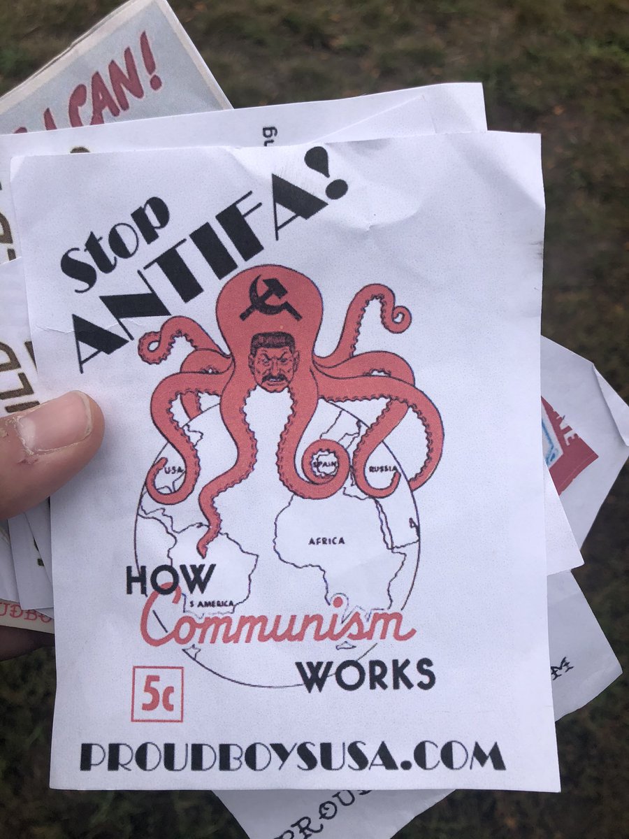 They’re handing out fliers / stickers in the style of WWII and Red Scare-eta art.