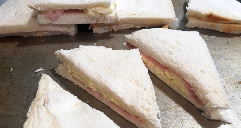Traditionally it was made with sliced home-made bread, as a way of making both the cheese and the bread itself go a bit further. These days you make it using white sandwich bread. Cut off the crusts, then make little sandwiches fill cheese and ham or anchovies or what you like.