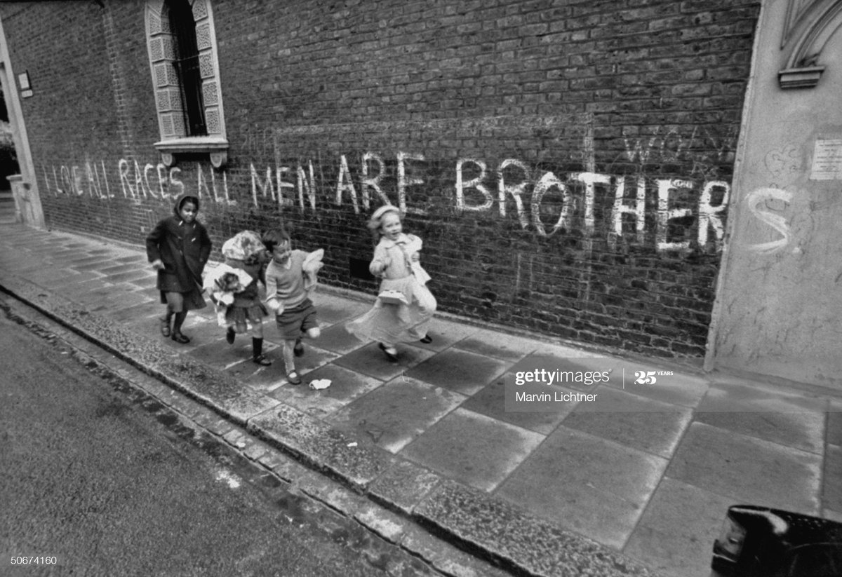 No one is born racist .Children playing on the street in London in 1968. The graffiti behind them states 'I Love All Races, All Men Are Brothers' Photo by Marvin Lichtner