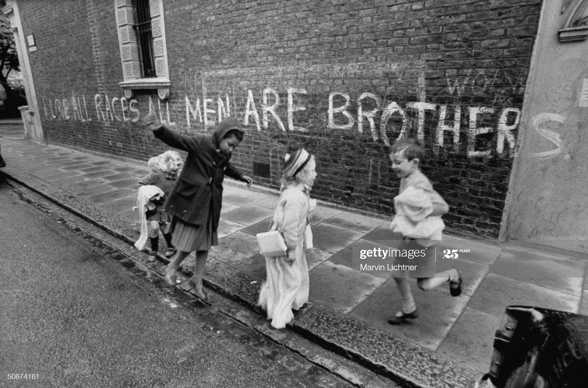 No one is born racist .Children playing on the street in London in 1968. The graffiti behind them states 'I Love All Races, All Men Are Brothers' Photo by Marvin Lichtner