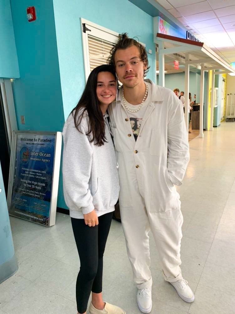 jan 5 2020: harry in ~winter white~ down to the still-new vans. at the airport again, starting to think the vans are his designated travel shoe. a practical king. side note this jumpsuit/hairstyle/necklace combo has me feeling some type of way